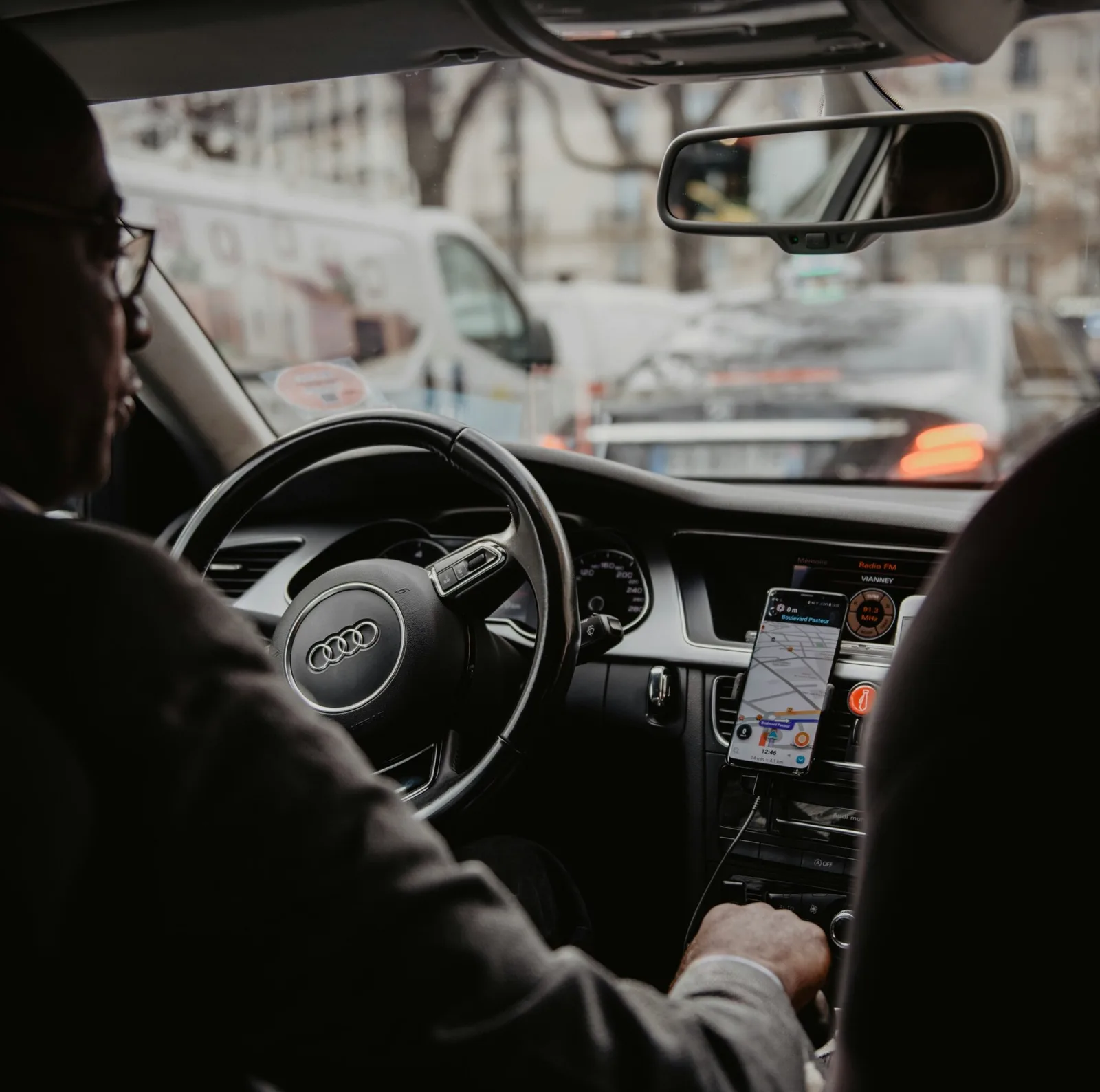Schipholride driver in a suit at the wheel, navigation and map on the dashboard during a ride