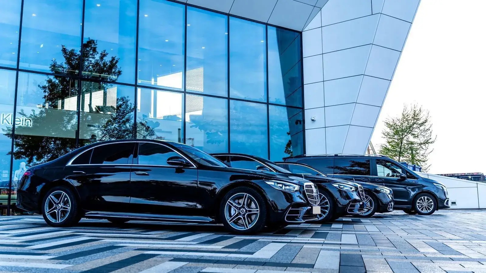 Mercedes S-Class en V-Class, inzetbaar via SchipholRide, voor een modern glazen kantoorgebouw