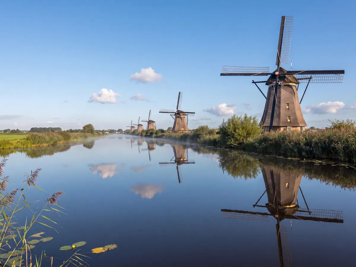 Row of windmills along a canal in the polder