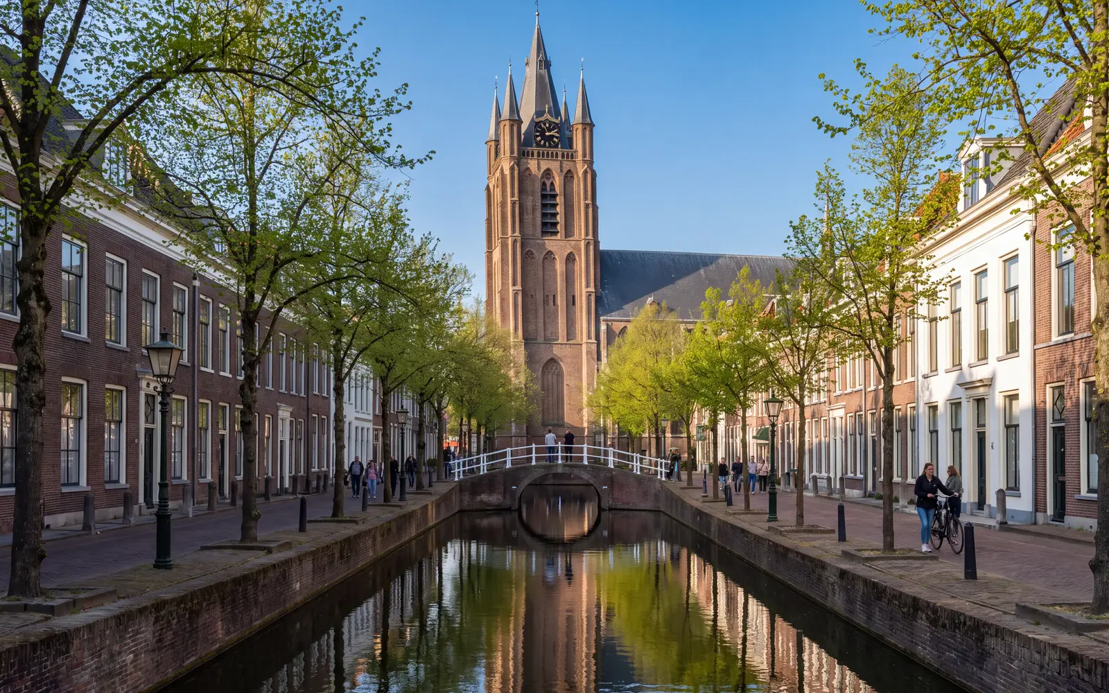 De Oude Delft in Delft met de scheve toren van de Oude Kerk onder een blauwe lucht