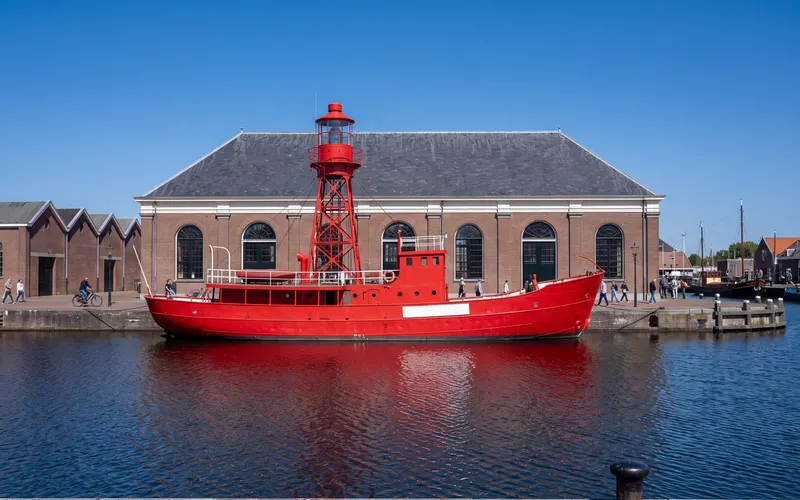 Het rode lichtschip Texel in de museumhaven van Willemsoord in Den Helder, met de oude Mastenloods erachter