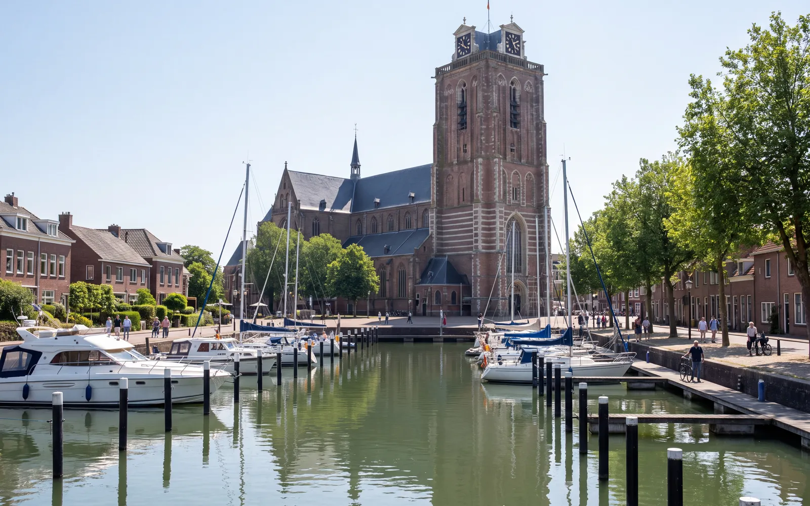 The Nieuwe Haven in Dordrecht with the tower of the Grote Kerk under a blue sky