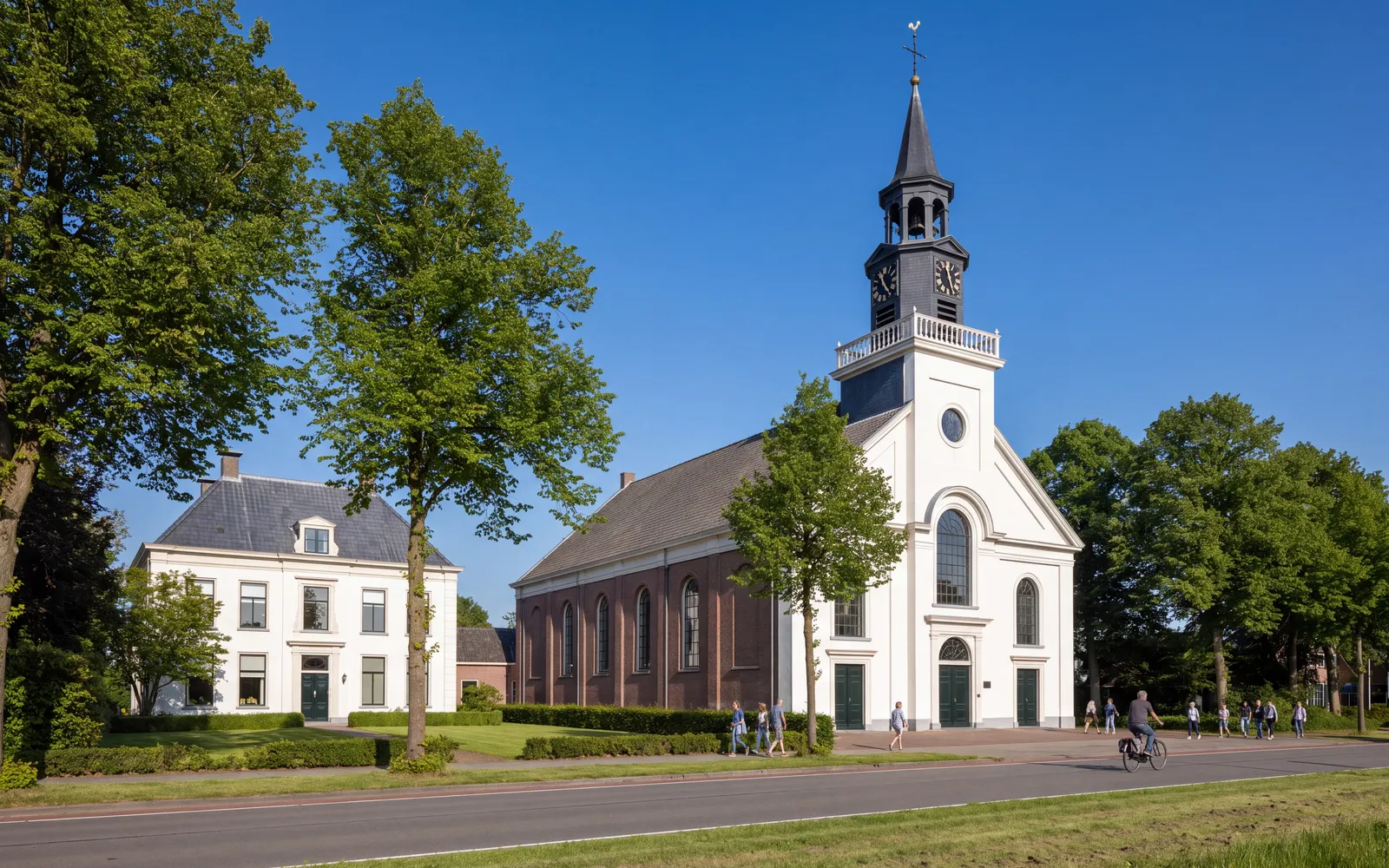 De witte Hoofdvaartkerk aan de Hoofdweg in Hoofddorp, met links de pastorie