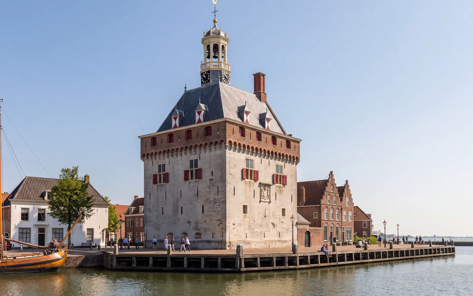 The Hoofdtoren in Hoorn, seen across the harbour under a blue sky