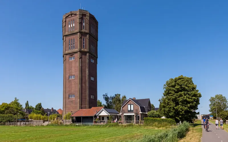 The water tower of Kwadijk above the houses along the dike, seen across the meadow