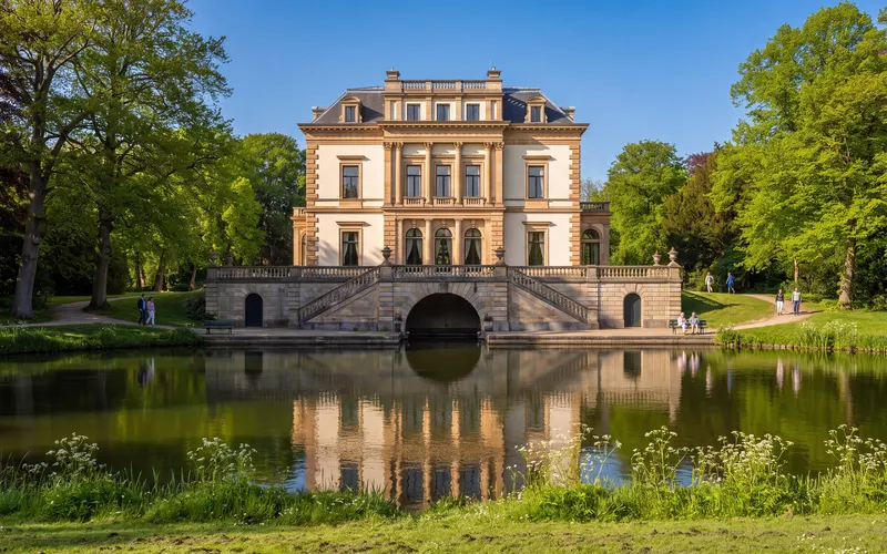 Huis Elswout on the Elswout estate in Overveen, seen across the water under a blue sky