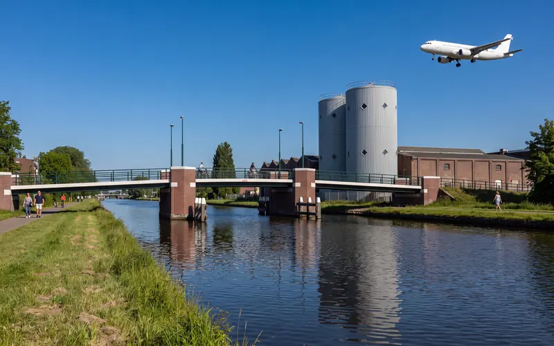 De Ringvaart bij Zwanenburg met de Bietenbrug, een vliegtuig op weg naar Schiphol erboven